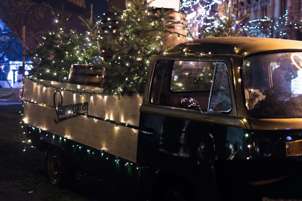 pexels-photo-824257-824257 A vintage truck adorned with Christmas lights and trees, creating a festive atmosphere at night.